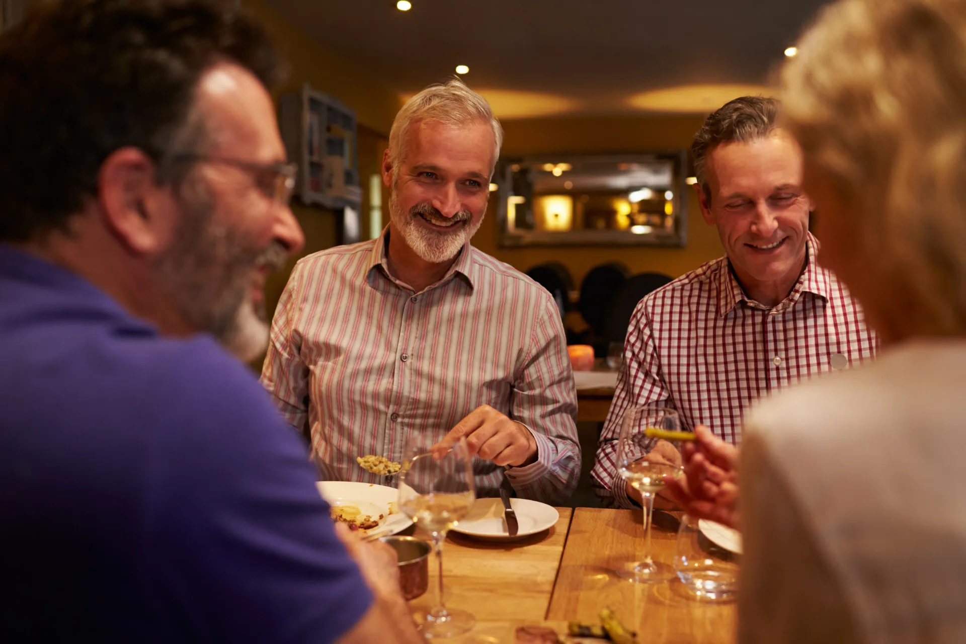 Adult experiencing difficulty hearing conversation in a noisy restaurant in Arvada Colorado.